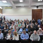 The auditorium is full of faculty members, students and employees